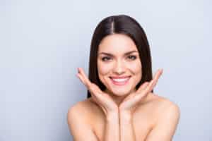 A young woman smiling and showing the results of preventative BOTOX® Cosmetic injections